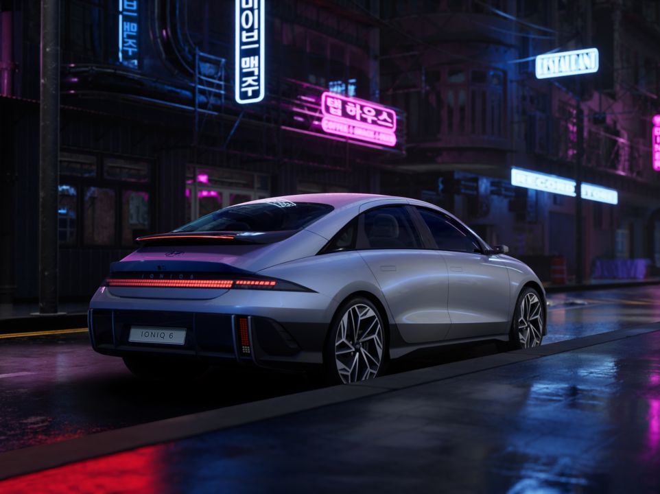 A silver car is parked on the side of a city street at night. Ioniq 6