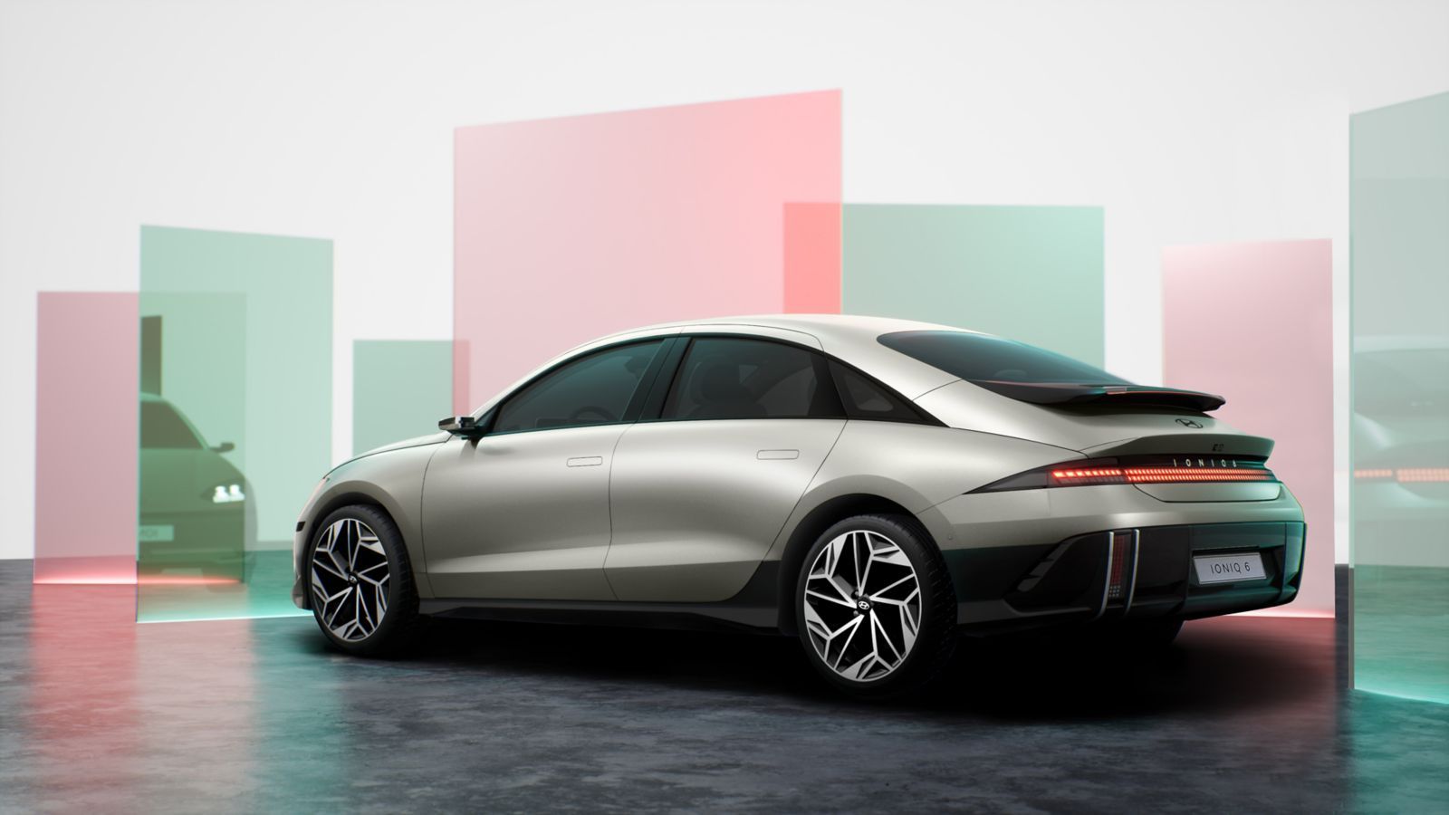 A silver car is parked in a parking lot in front of a building. Ioniq 6