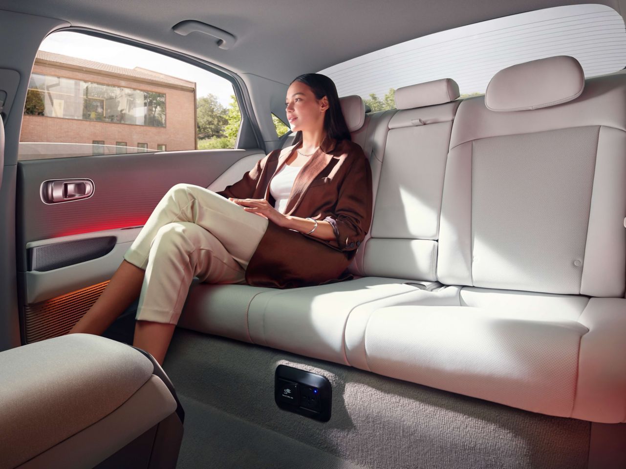 A woman is sitting in the back seat of a car. Ioniq 6