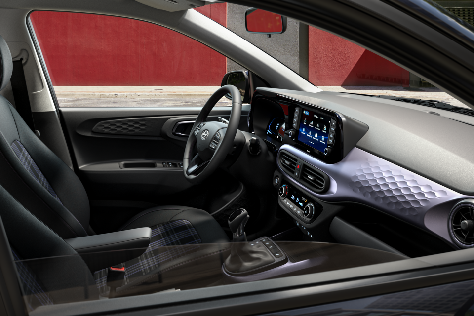 The interior of a car with a red wall in the background. i10