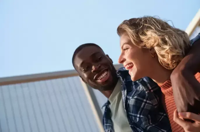 A man and a woman are sitting next to each other and smiling.