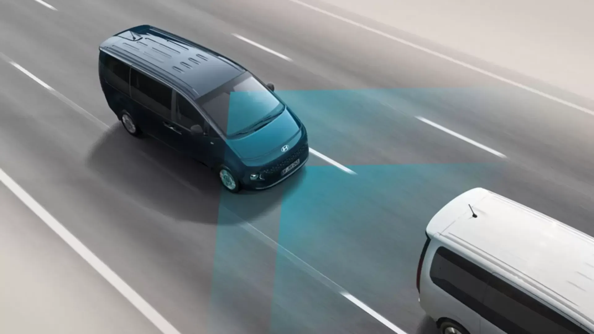 A van is driving down a highway next to a bus. Staria
