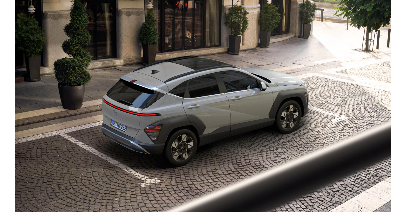A car is parked in a parking lot on a cobblestone street. Kona