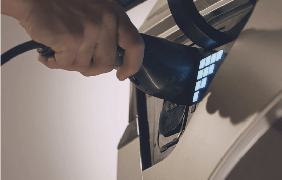 A person is charging an electric car with a charger