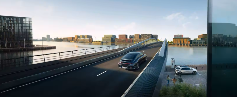 A car is driving on a bridge over a body of water.