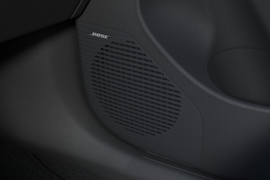 A close up of a speaker in a car door. Kona