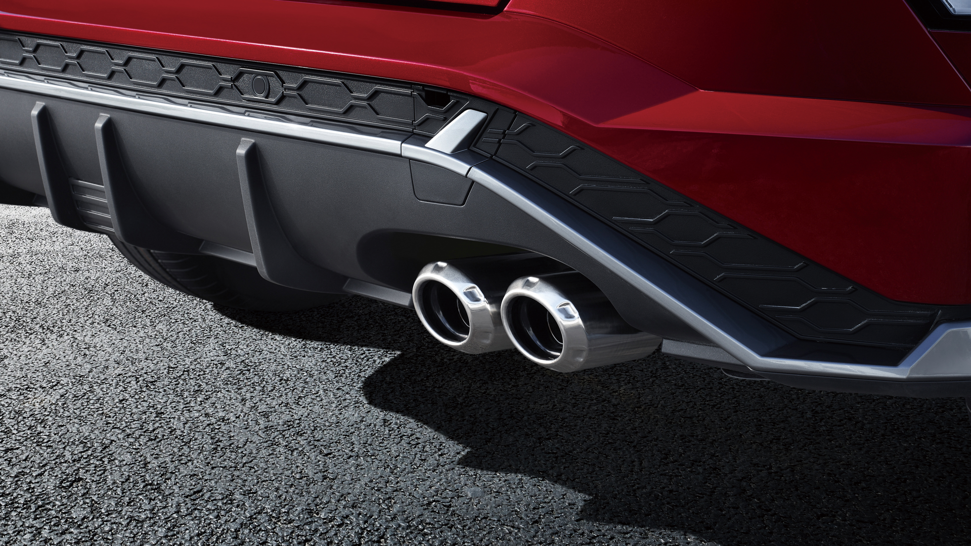 A close up of a red car 's exhaust pipes