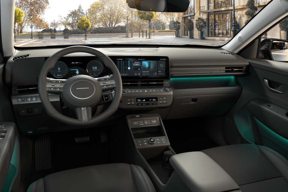 The interior of a car with a steering wheel and dashboard. Kona