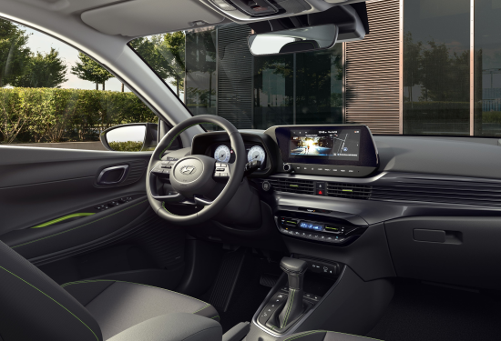The interior of a car with a steering wheel and a dashboard. i20