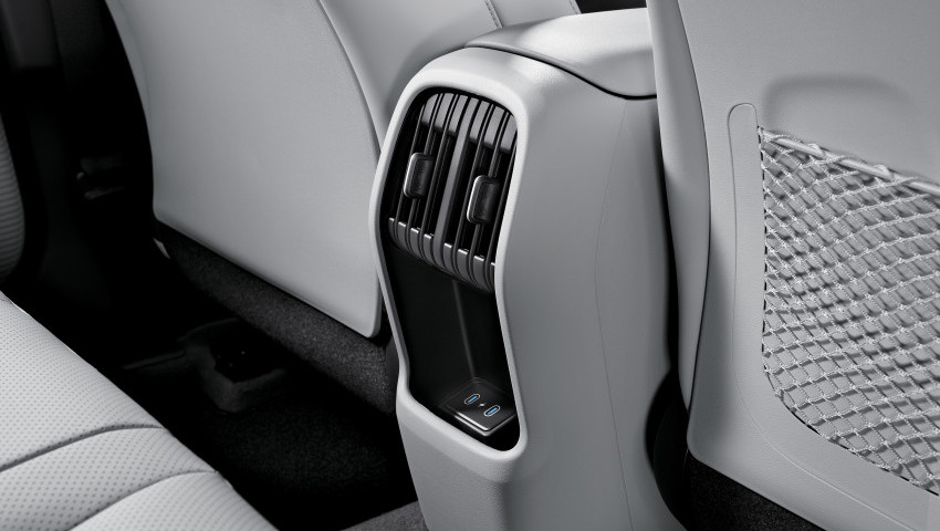 A black and white photo of the back seat of a car. Kona
