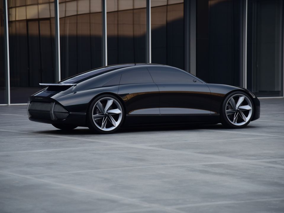 A black car is parked in a parking lot in front of a building. Ioniq 6