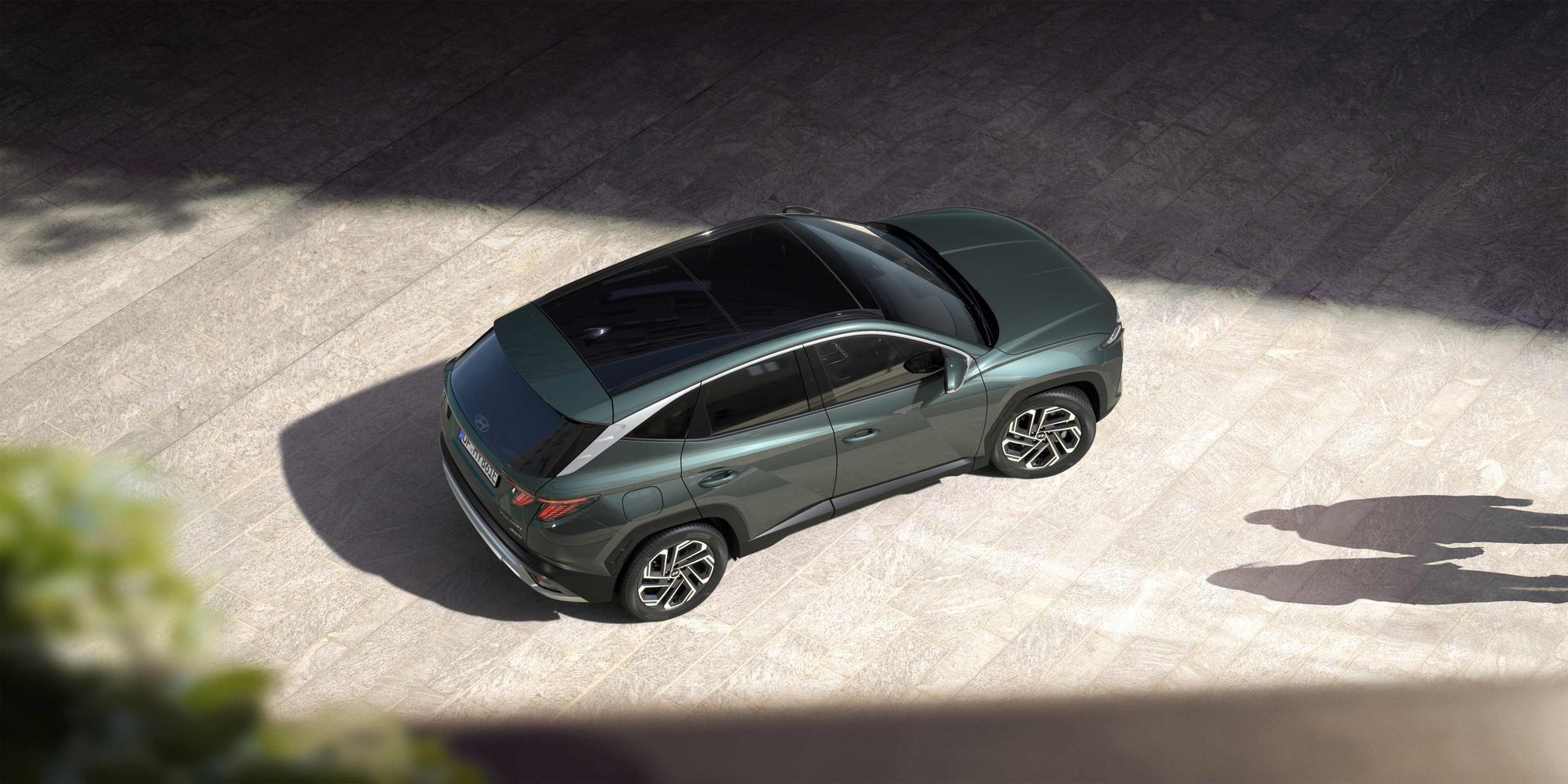An aerial view of a green car parked on the side of the road. Tucson