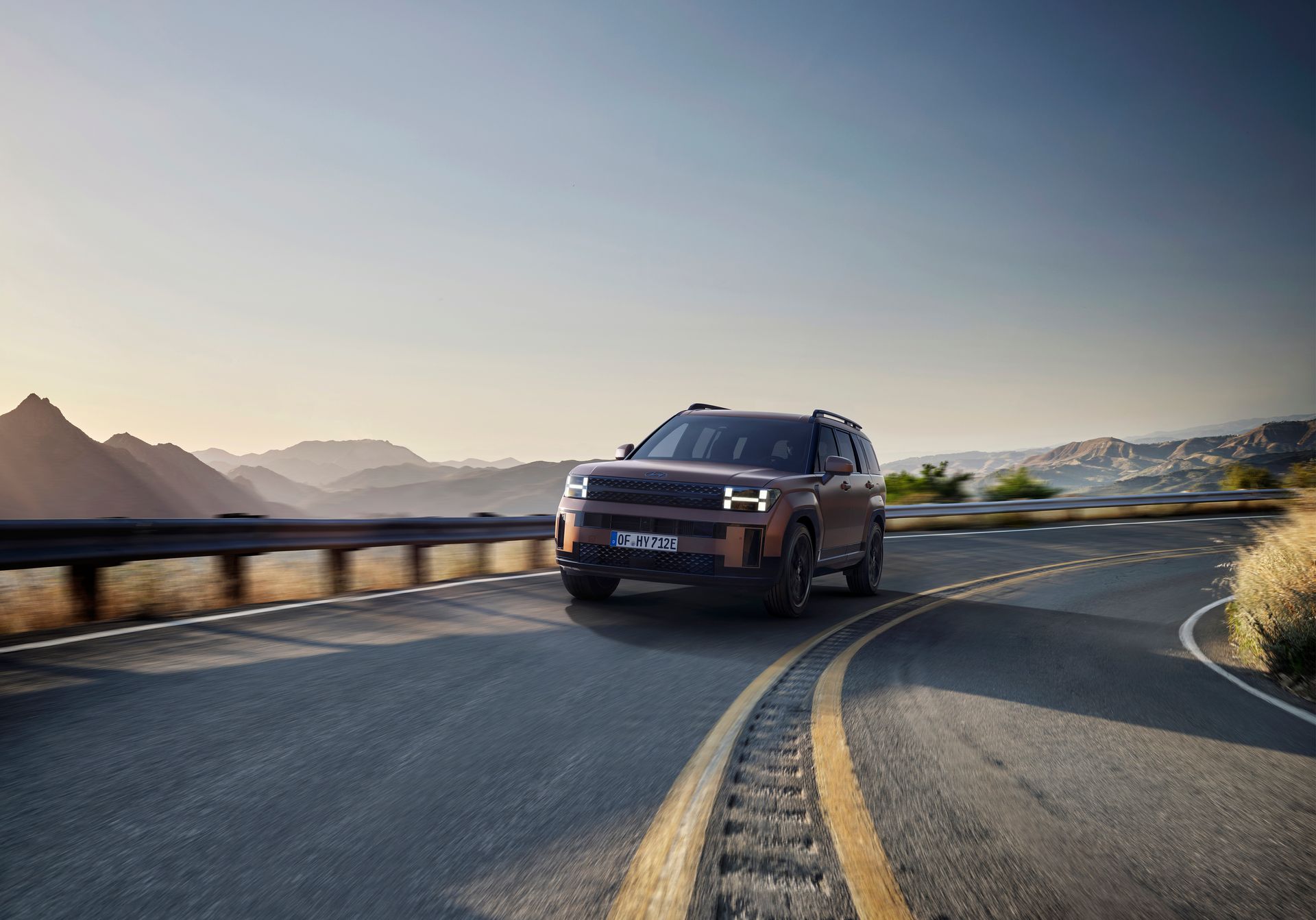 A jeep renegade is driving down a curvy road.