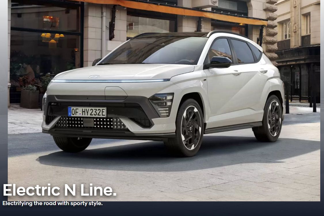 A white hyundai kona electric n line is parked on a city street.