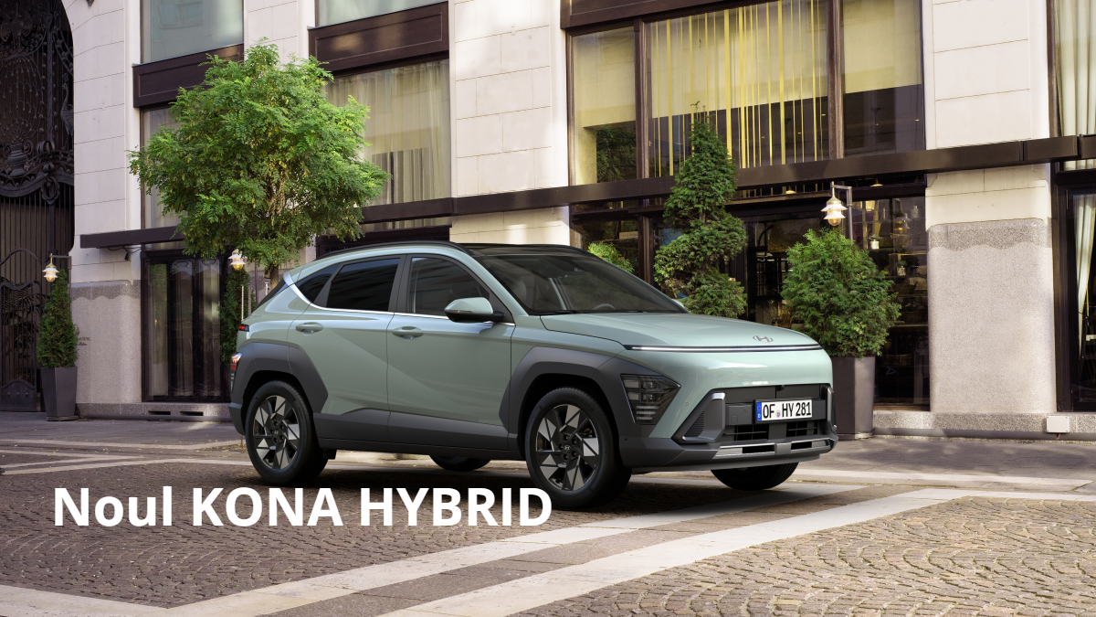 A hyundai kona hybrid is parked in front of a building.  