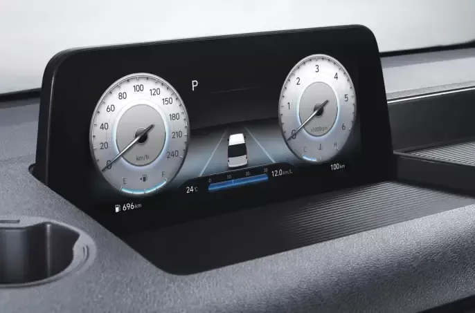 A car dashboard with a clock and a speedometer Staria