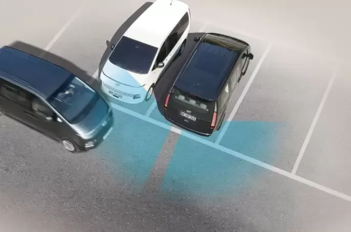 A group of cars are parked in a parking lot. Staria