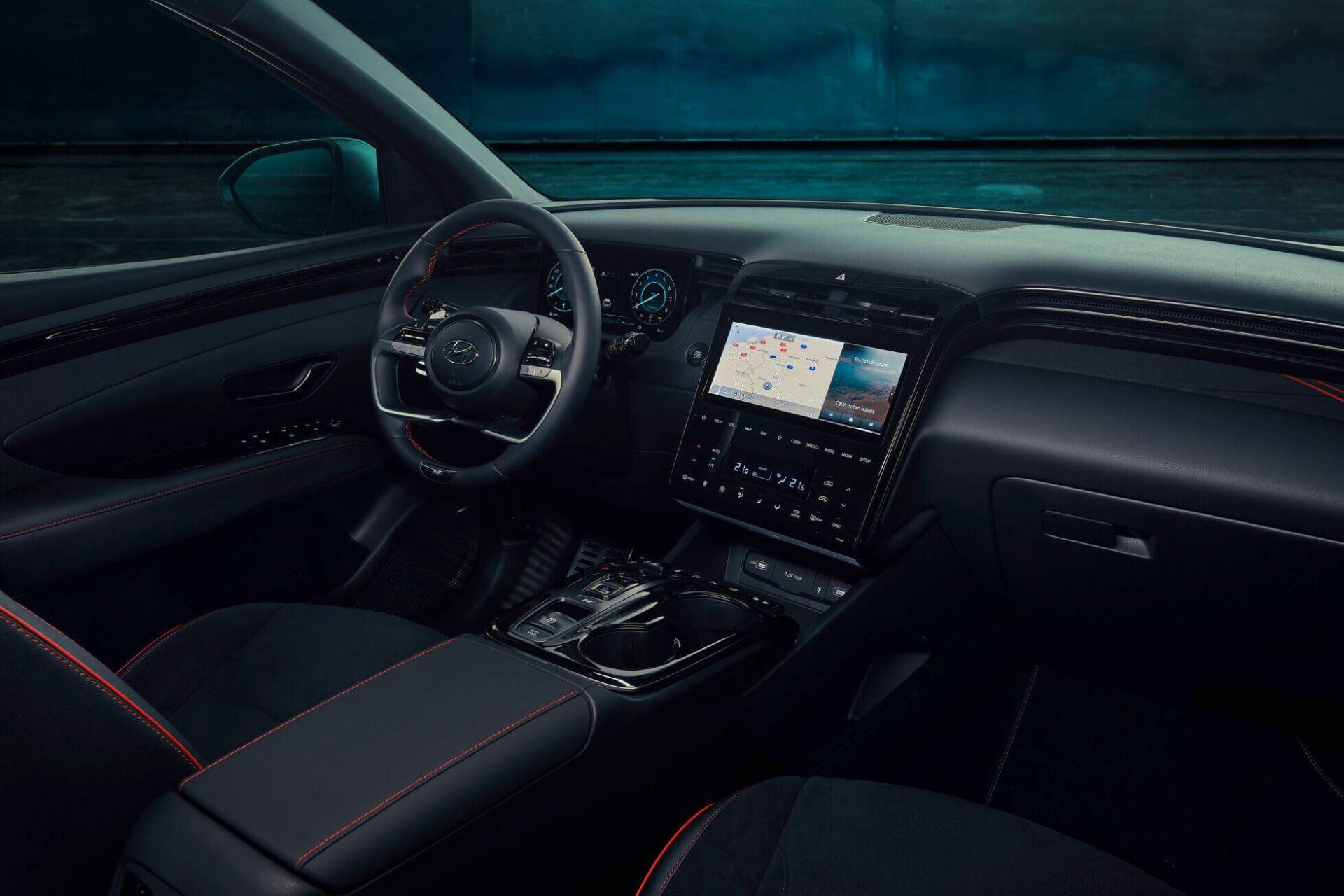 The interior of a car with a steering wheel and a dashboard. Tucson