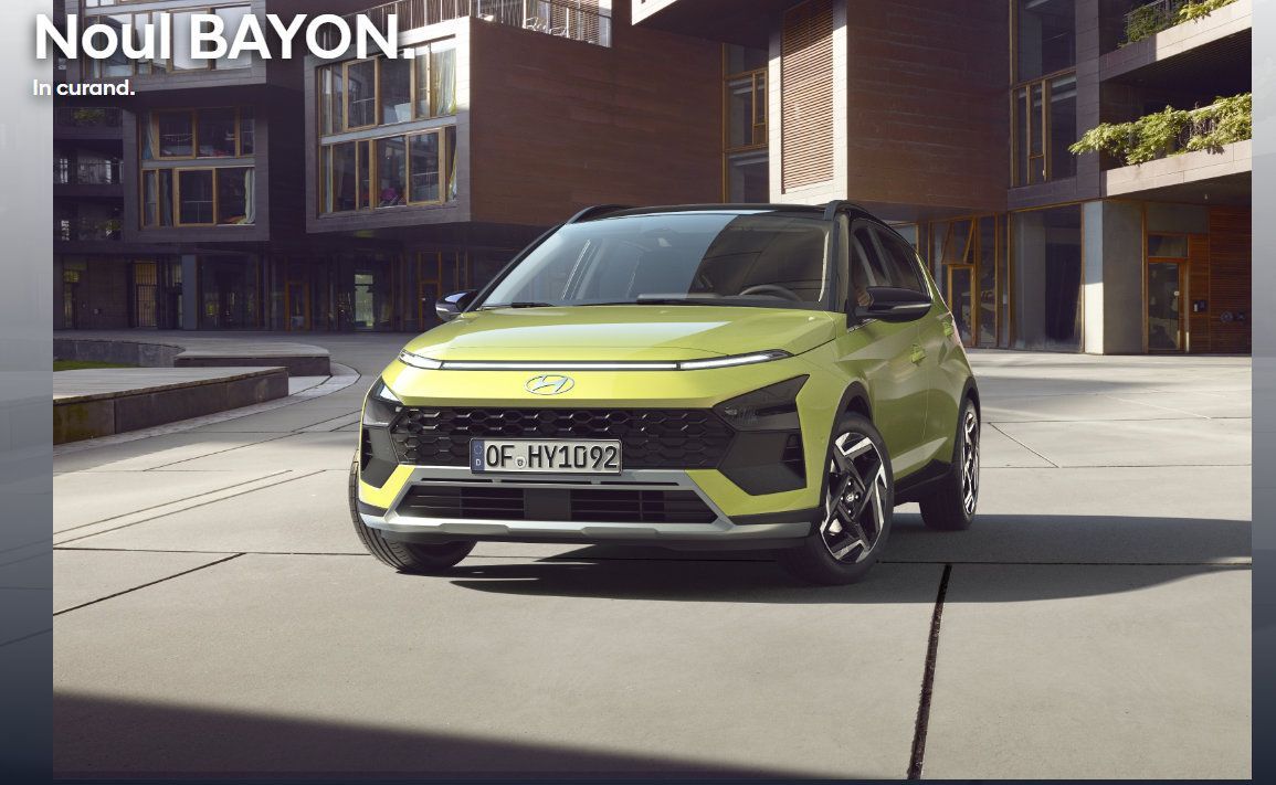 A yellow car is parked on the side of the road in front of a building. Bayon
