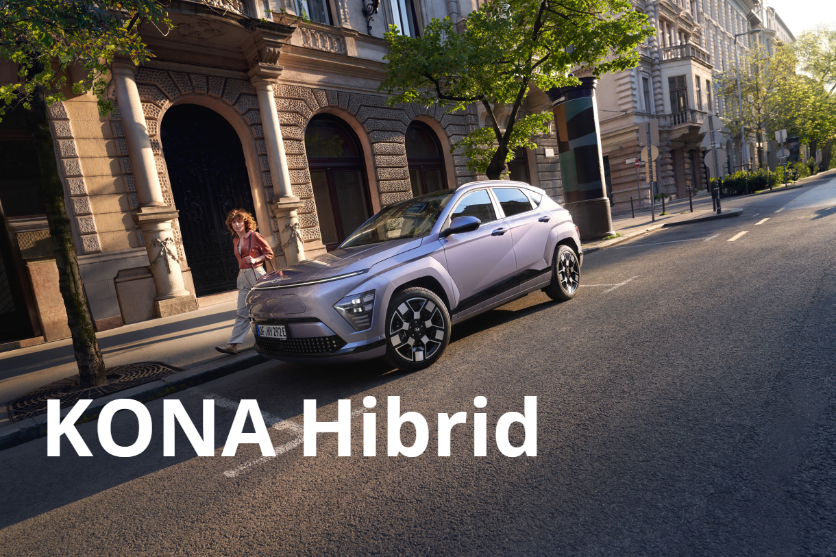 A hyundai kona hybrid is parked on the side of the road in front of a building.