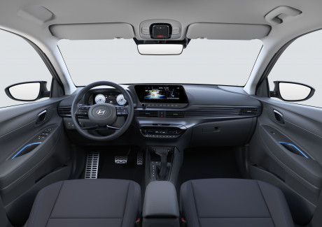 The interior of a car with a steering wheel and a dashboard. Bayon