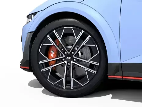 A close up of the front wheel of a blue car with a black rim. Ioniq 5 N