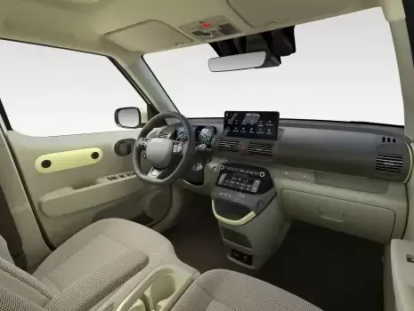 The interior of a car with a steering wheel and a dashboard. Inster