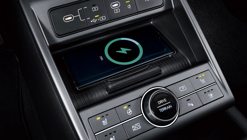 A wireless charger is sitting on top of a car dashboard. Kona