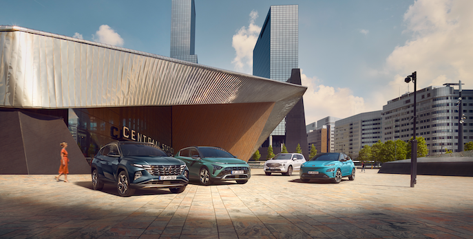 A group of cars are parked in front of a building in a city.