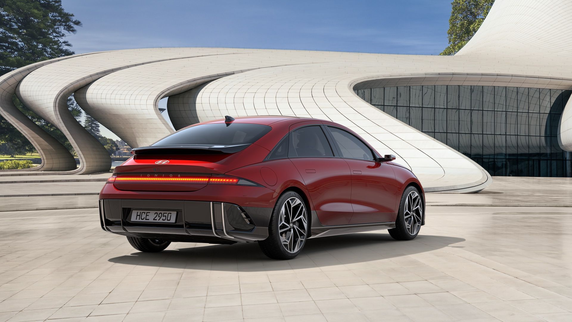 A red car is parked in front of a building. Ioniq 6