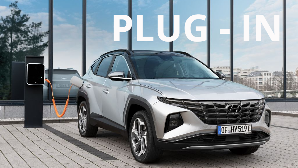 A silver car is being charged at a charging station. Tucson