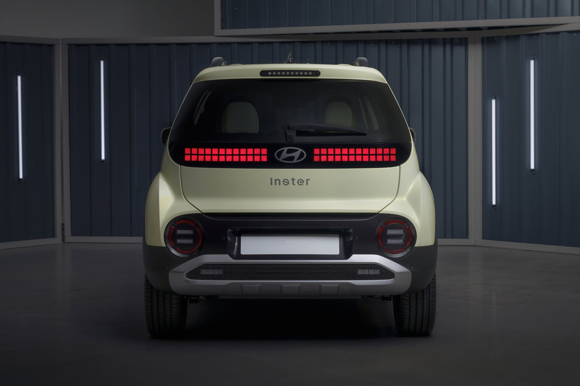 The rear end of a car is shown in a garage. Inster