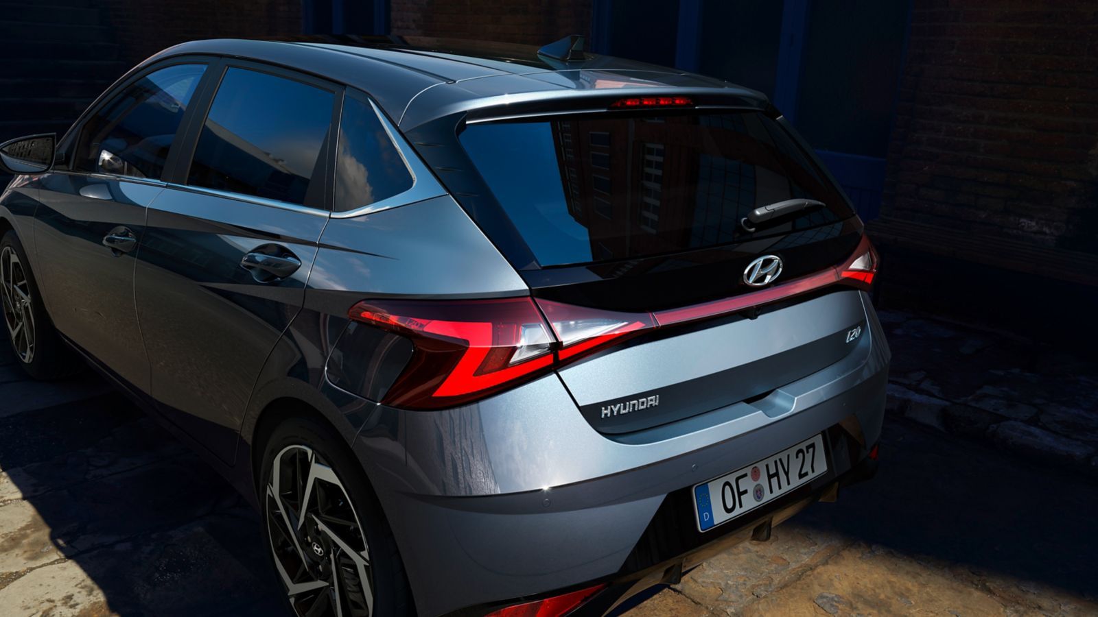 A hyundai i20 hatchback is parked in front of a building. i20