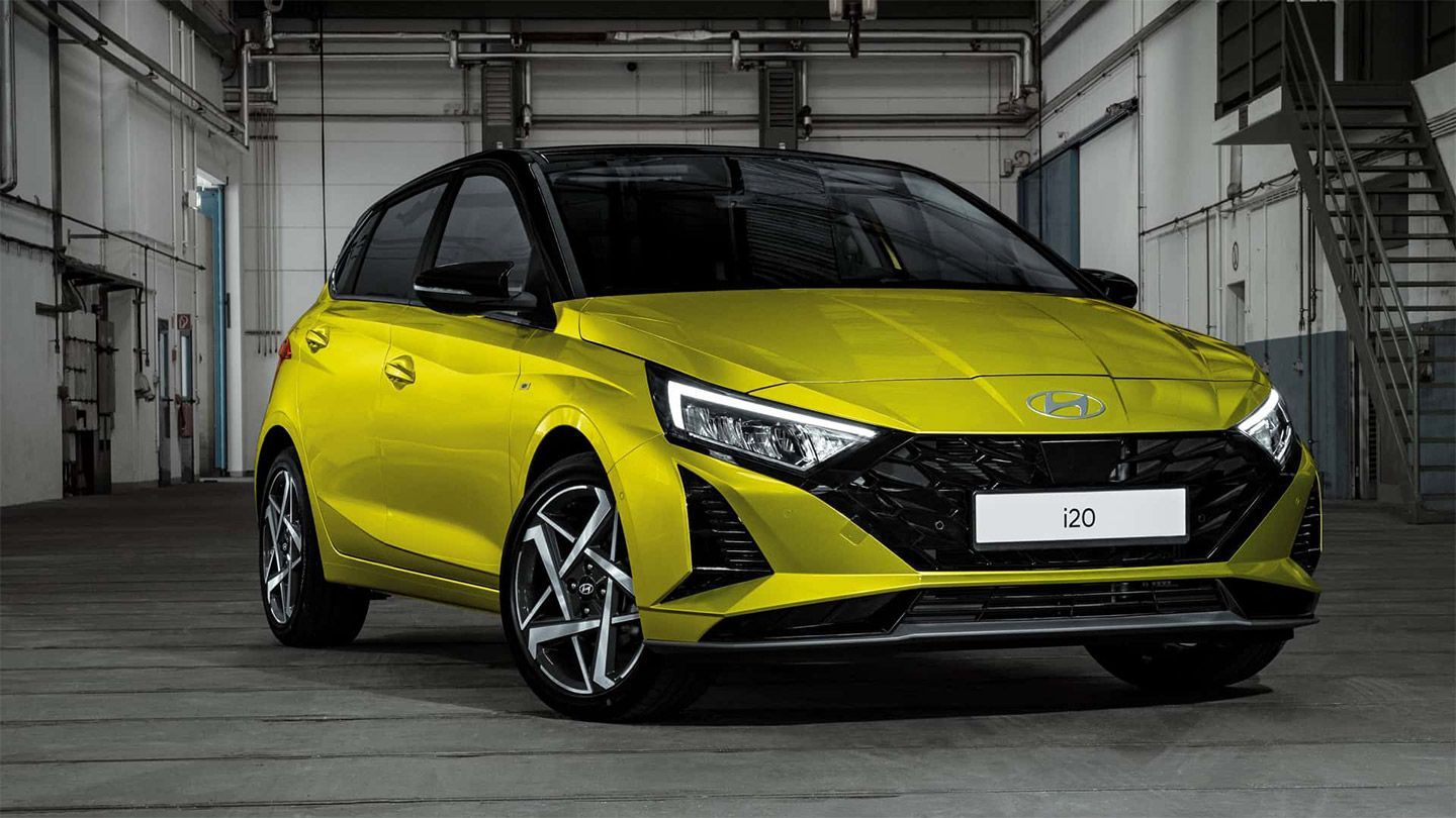 A yellow hyundai i20 hatchback is parked in a garage.