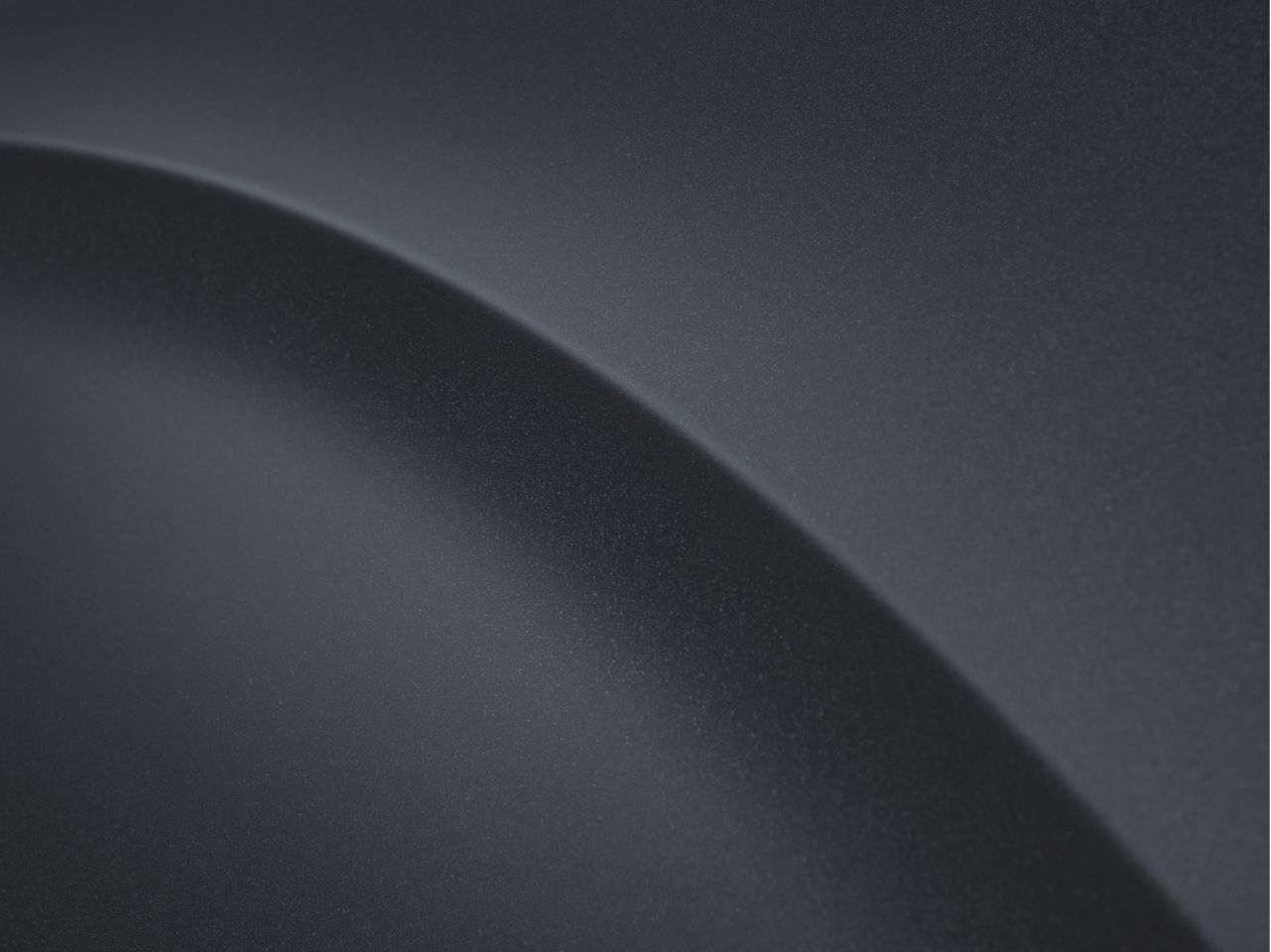 A close up of a black surface with a curve in the middle.
