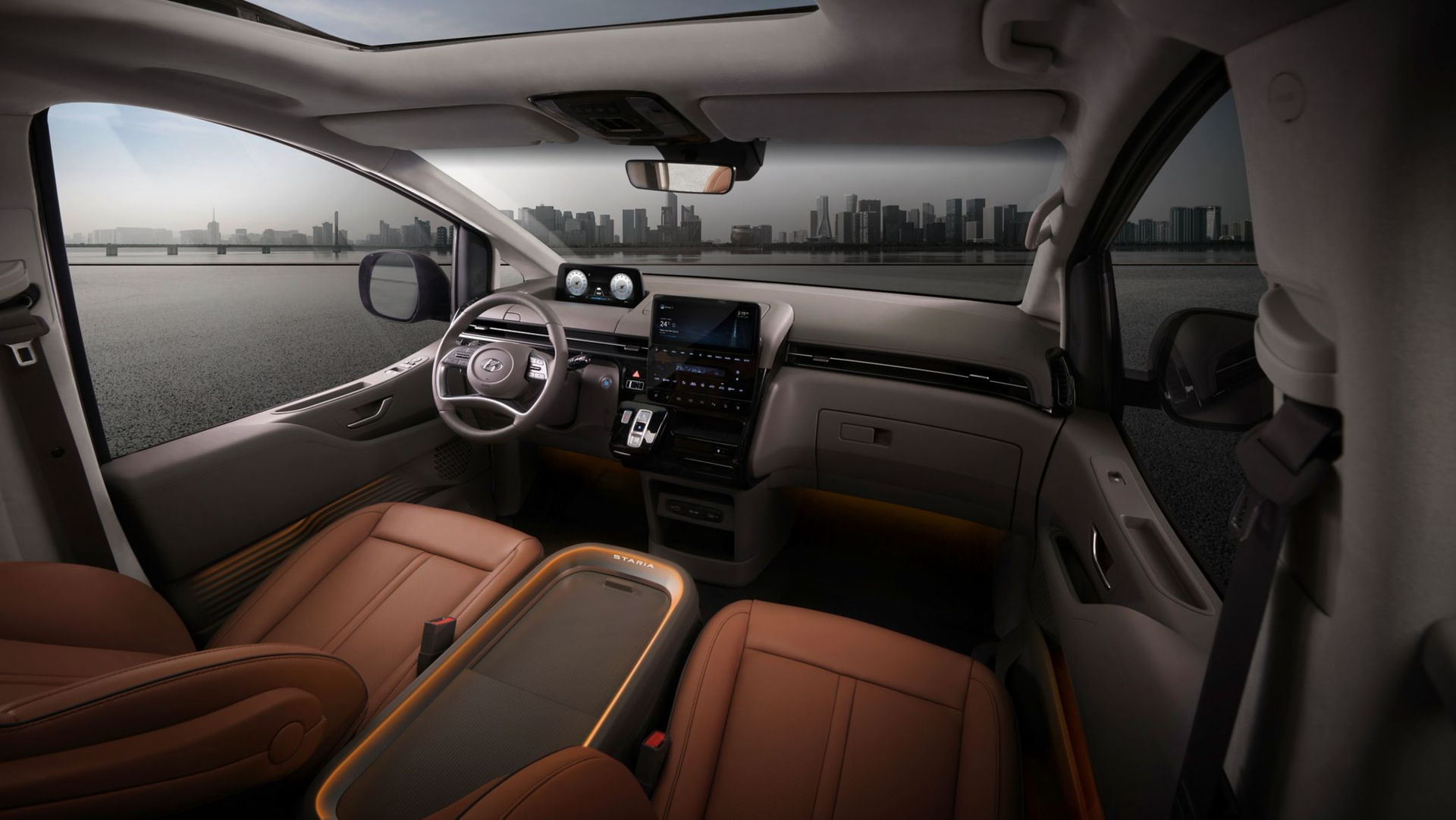 The interior of a minivan with brown leather seats and a sunroof. Staria