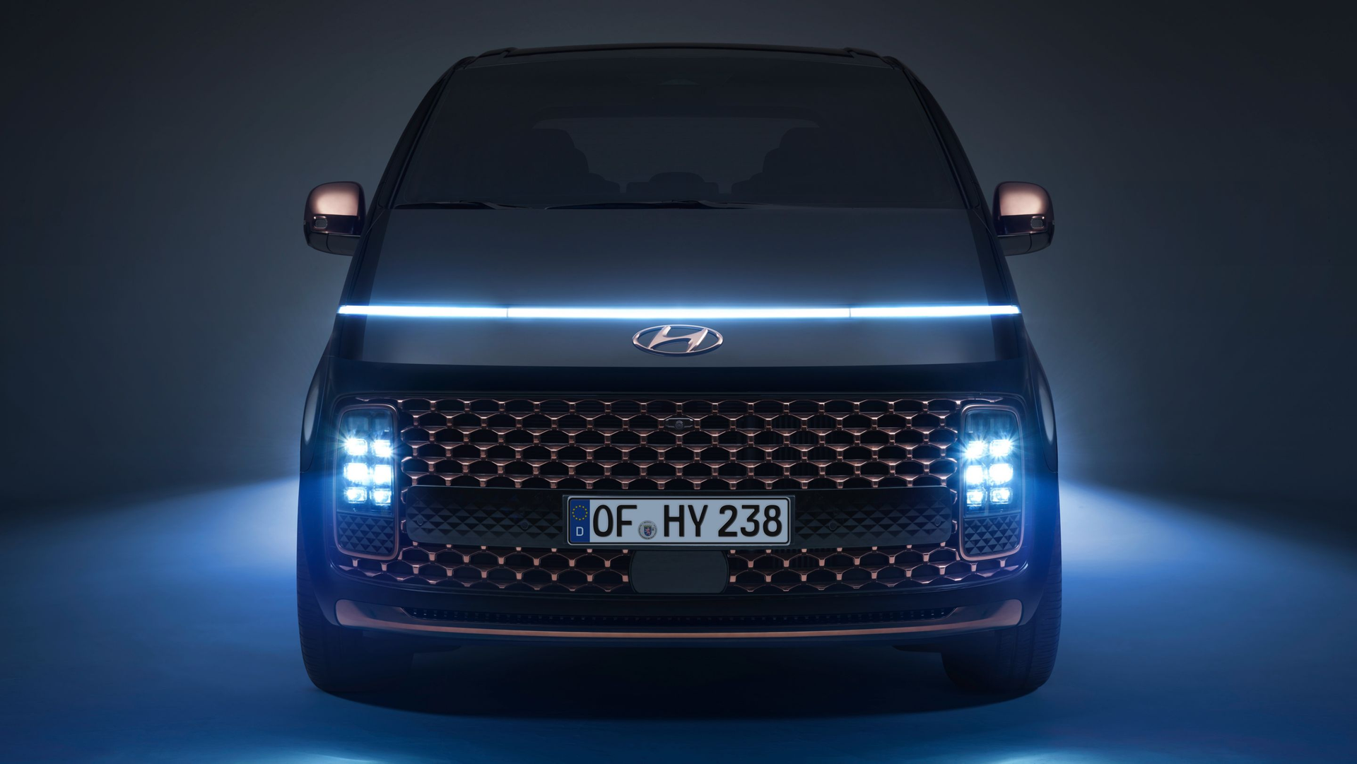 The front of a black van with blue lights on it. Staria