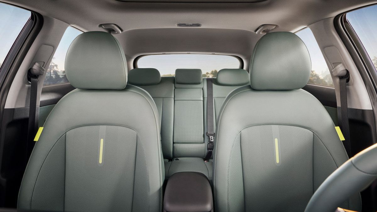 The interior of a car with green seats and a sunroof. Kona