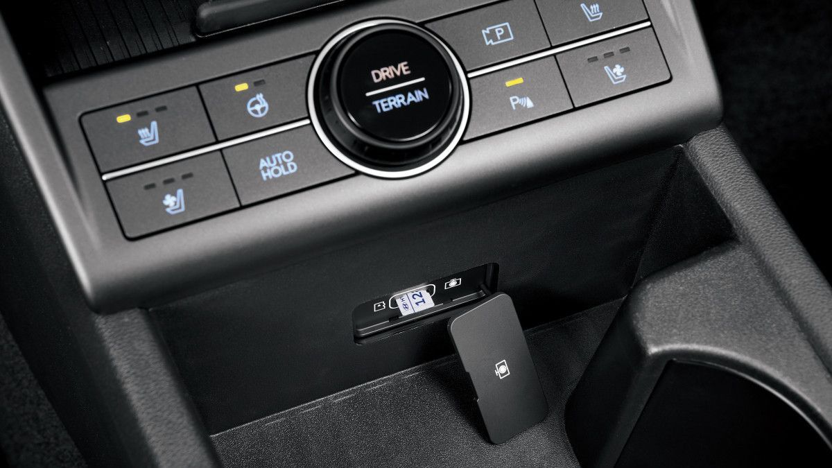 A close up of a car dashboard with a cup holder. Kona