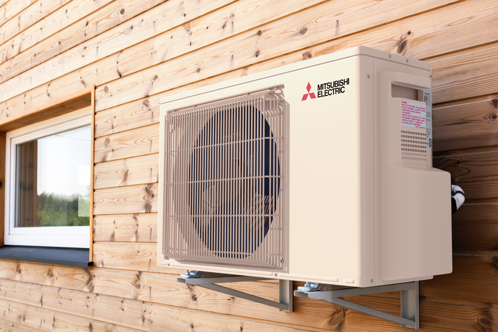 A white air conditioner is mounted on a wooden wall next to a window.
