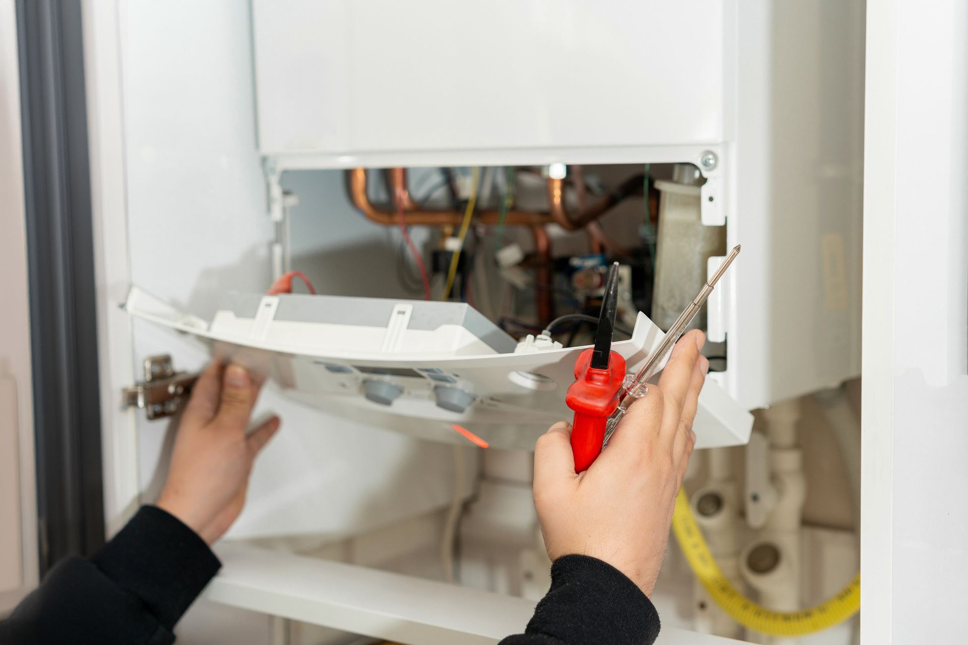 HVAC technician servicing a residential heating system in a Fairport New York home.