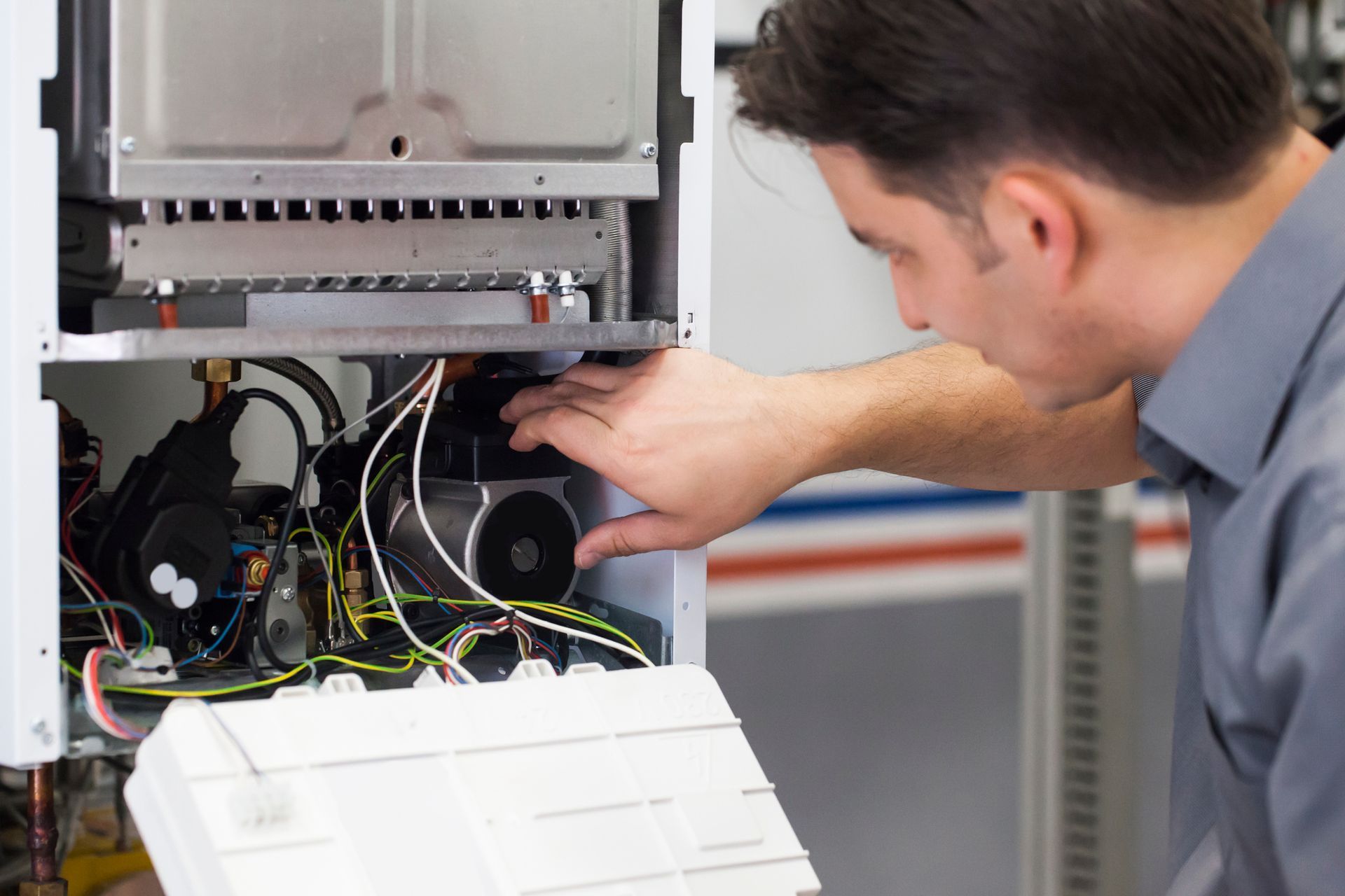 HVAC technician repairing a residential gas furnace during a winter heating service appointment.