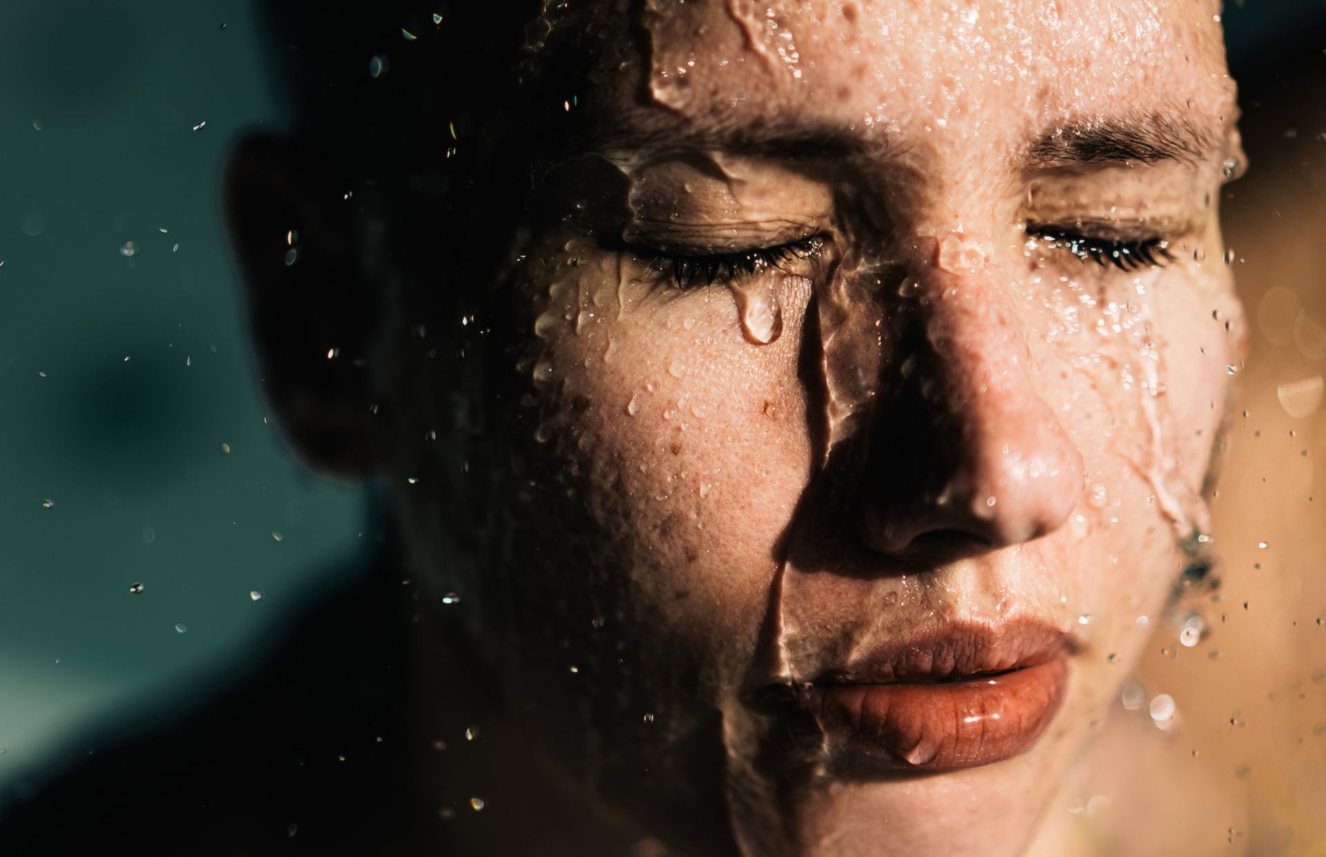 A close up of a person 's face with water coming out of it.
