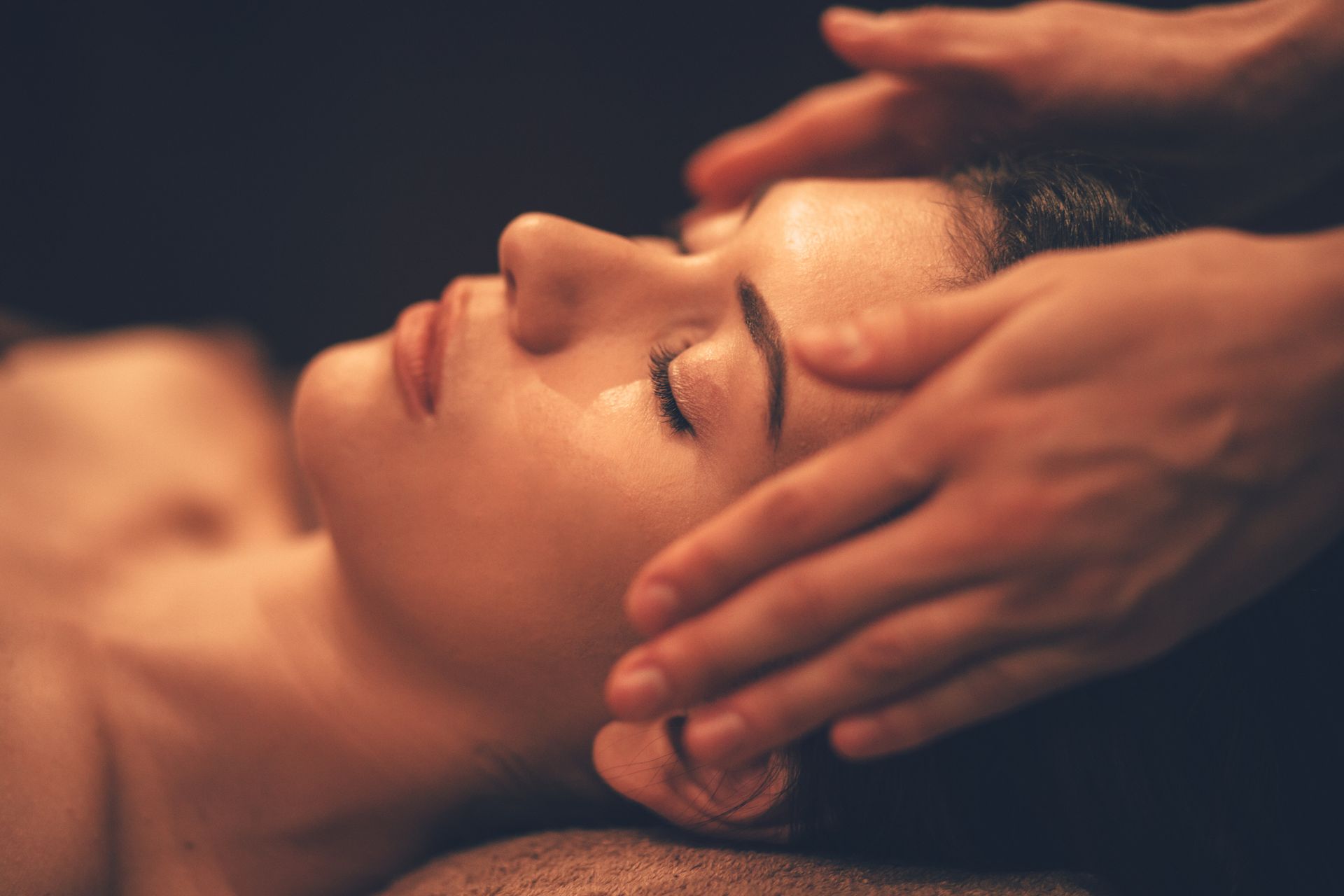 A woman is getting a head massage at a spa.