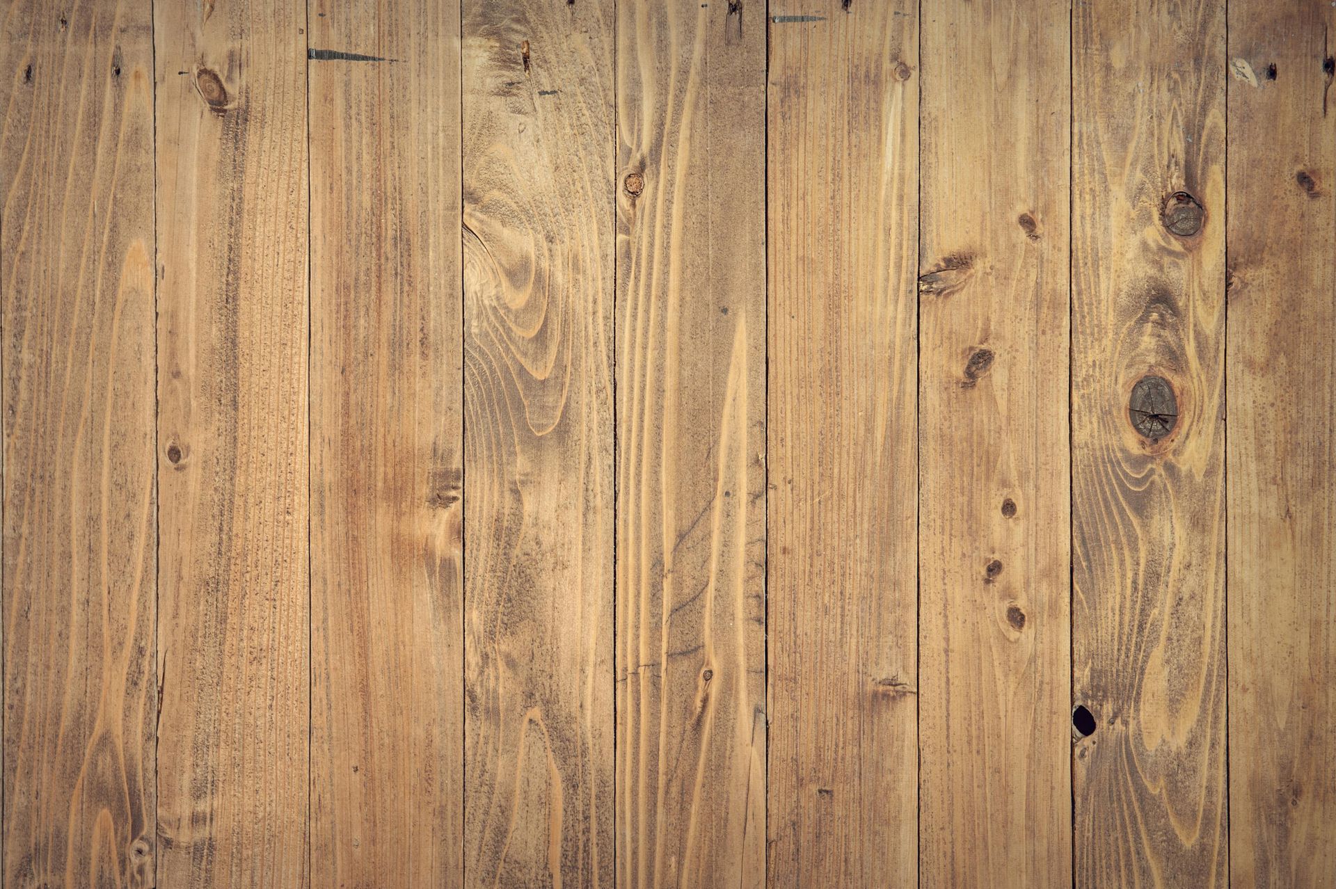 Wooden planks, vertical, varying shades of brown, with knots and grain detail.