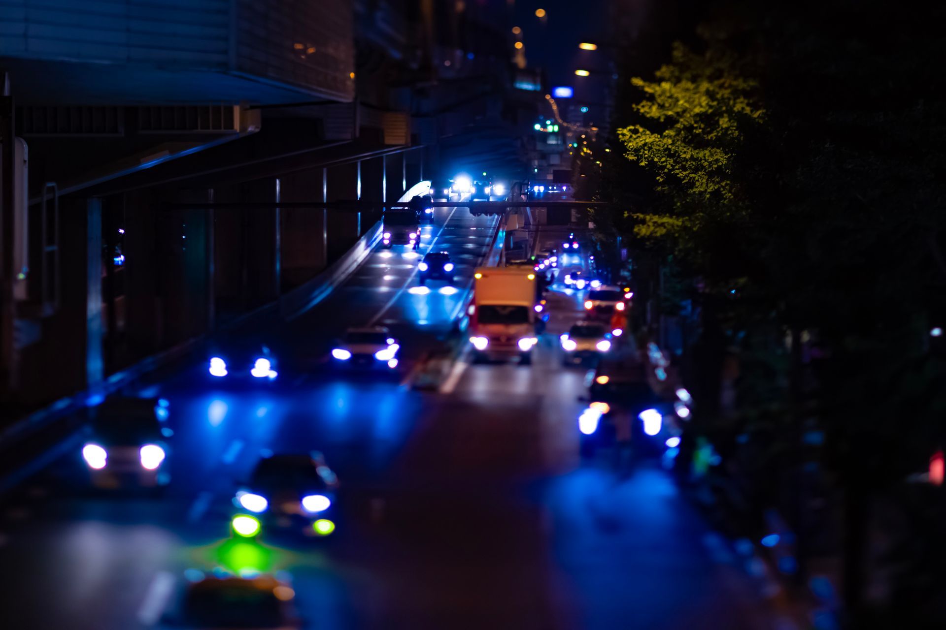 A blurry picture of a city street at night with cars driving down it.