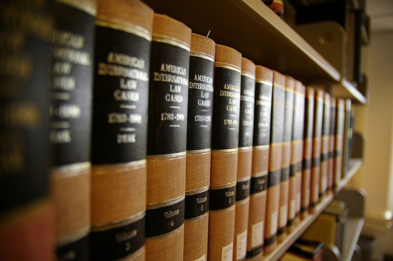 Row of law books on a shelf; black spines with gold lettering, tan bindings.