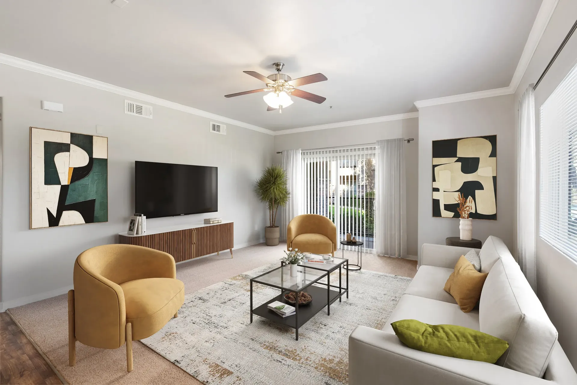 Modern apartment living room with a white sofa, mustard chairs, coffee table, TV, and large windows at Wolf Ranch Apartments.