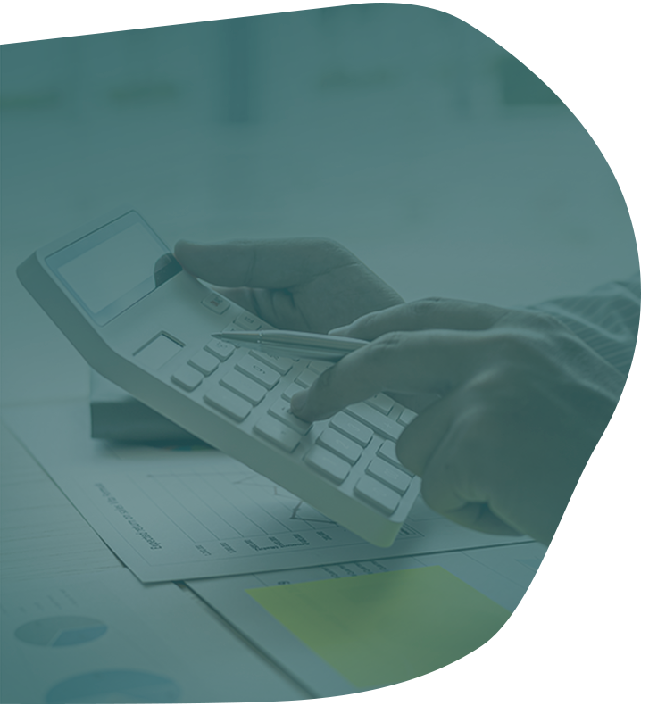 Hands using a calculator over financial documents and a yellow sticky note.