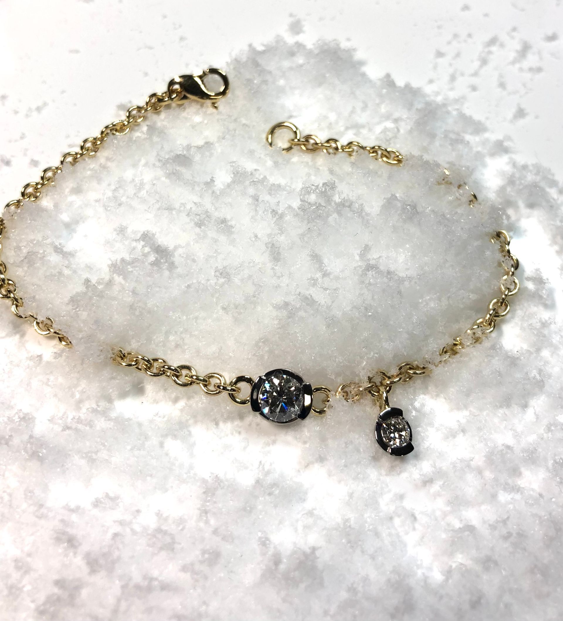 Ein goldenes Armband liegt auf einem Schneehaufen